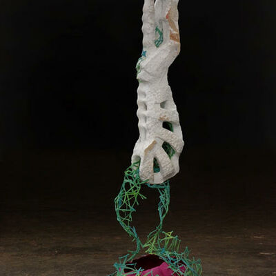 Marc Bertram, Titel der Skulptur: Veggied. An einem Seil hängt ein weißes Element an dem wiederum ein grünes Netz mit rotem Inhalt hängt.