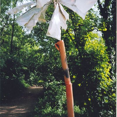 Eine Skulptur des Künstlerin von Ute Best auf dem ein dünner Holzstamm und einer weißen Flagge.