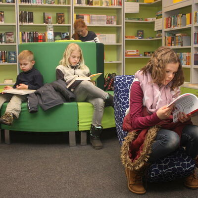 Auf der Fotografie sind 4 Kinder beim Lesen in der Kreisbücherei Lengede abgebildet.