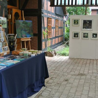 Kunsthof Mehrum, auf dieser Fotografie ist der überdachte Eingangsbereich mit einem Verkaufsstand für gemalte Bilder abgebildet.