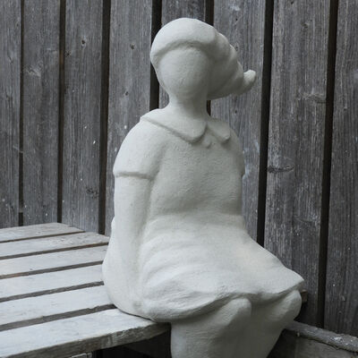 Diese Skulptur  von Anne Christine Reetz zeigt eine sitzende Person auf einer Bank.