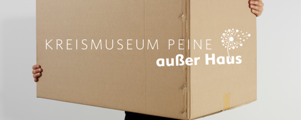 Hier ist das Logo des Kreismuseums Peine ausser Haus auf einer Pappkiste abgebildet.