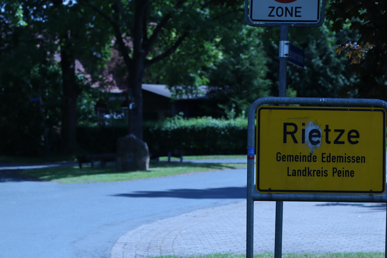 Das Ortsschild der Ortschaft Rietze lädt direkt zum Verweilen unter Bäumen ein.