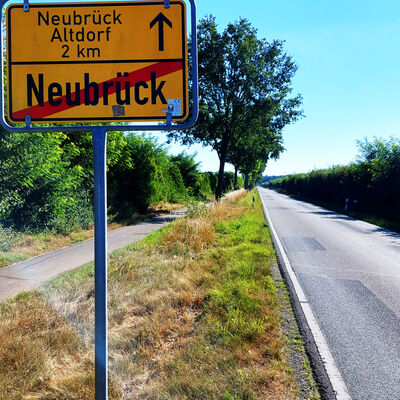 Ein Ortsschild weist auf das Verlassen des Ortes Neubrück nach Neubrück Altdorf hin.