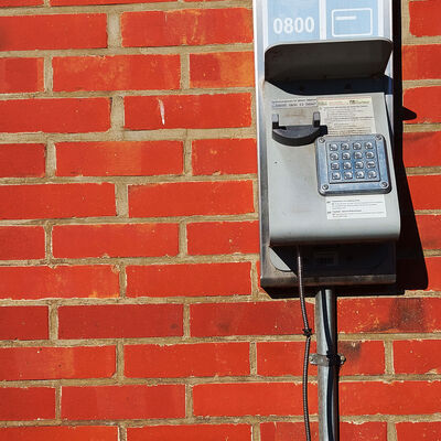 Ein Kartentelefon hängt in Neubrück in der Gemeinde Wendeburg an einer Wand.