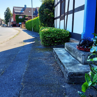 Das Werkzeug eines Schornsteinfegers liegt auf einer Treppe vor einer Haustür.