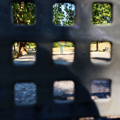 Der Blick auf einen Spielplatz durch das Metallgitter einer Tischtennisplatte in Sierße, eine Ortschaft in der Gemeinde Vechelde.
