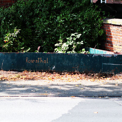 An einem Gegenstand am Straßenrand ist der Name des Ortes Rosenthal eingeschlagen.
