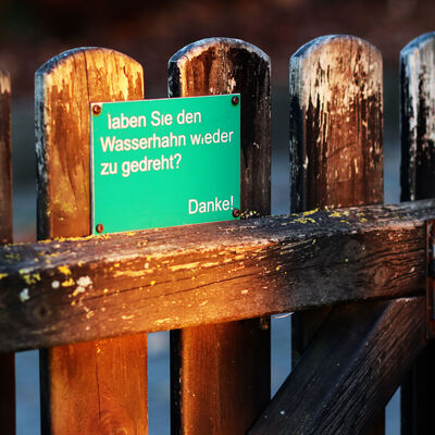 Auf einem Gartentor steht geschrieben "Haben Sie den Wasserhahn wieder zugedreht? Danke!. Das Schild wurde in der Ortschaft Bülten in der Gemeinde Ilsede gefunden.