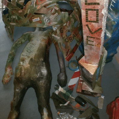 Eine Skulptur mit einer Figur und Backsteinen mit dem Schriftzug "LOVE" drauf.